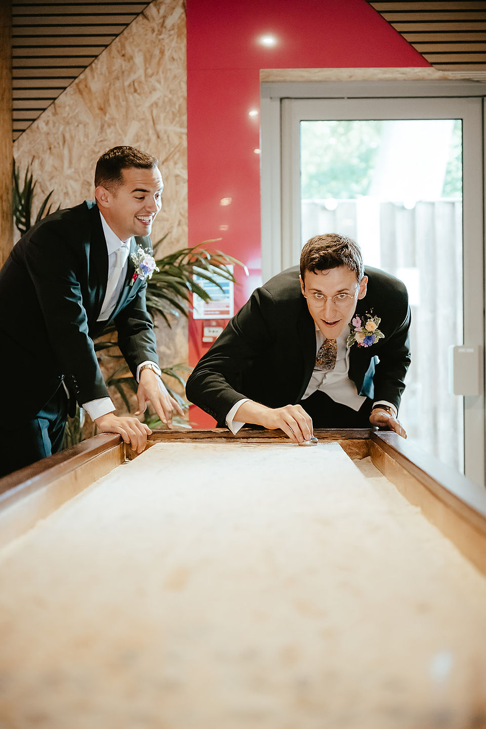groom and best man playing shuffle board once ready for the wedding ceremony