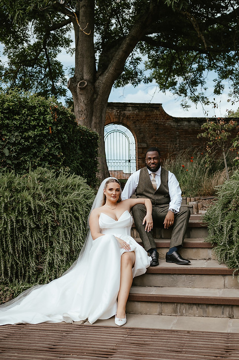 Bride and Groom sat on steps at Worstead Estate posing for Arienne
