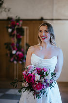 bride-laughing-holding-her-bright-pink-valentines-day-theamed-flowers