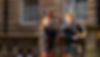 Scottish bagpipers in traditional kilt performing on a cobblestone street in Edinburgh