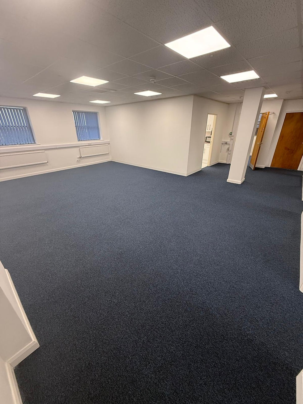 Empty office room with blue carpet and square lights.