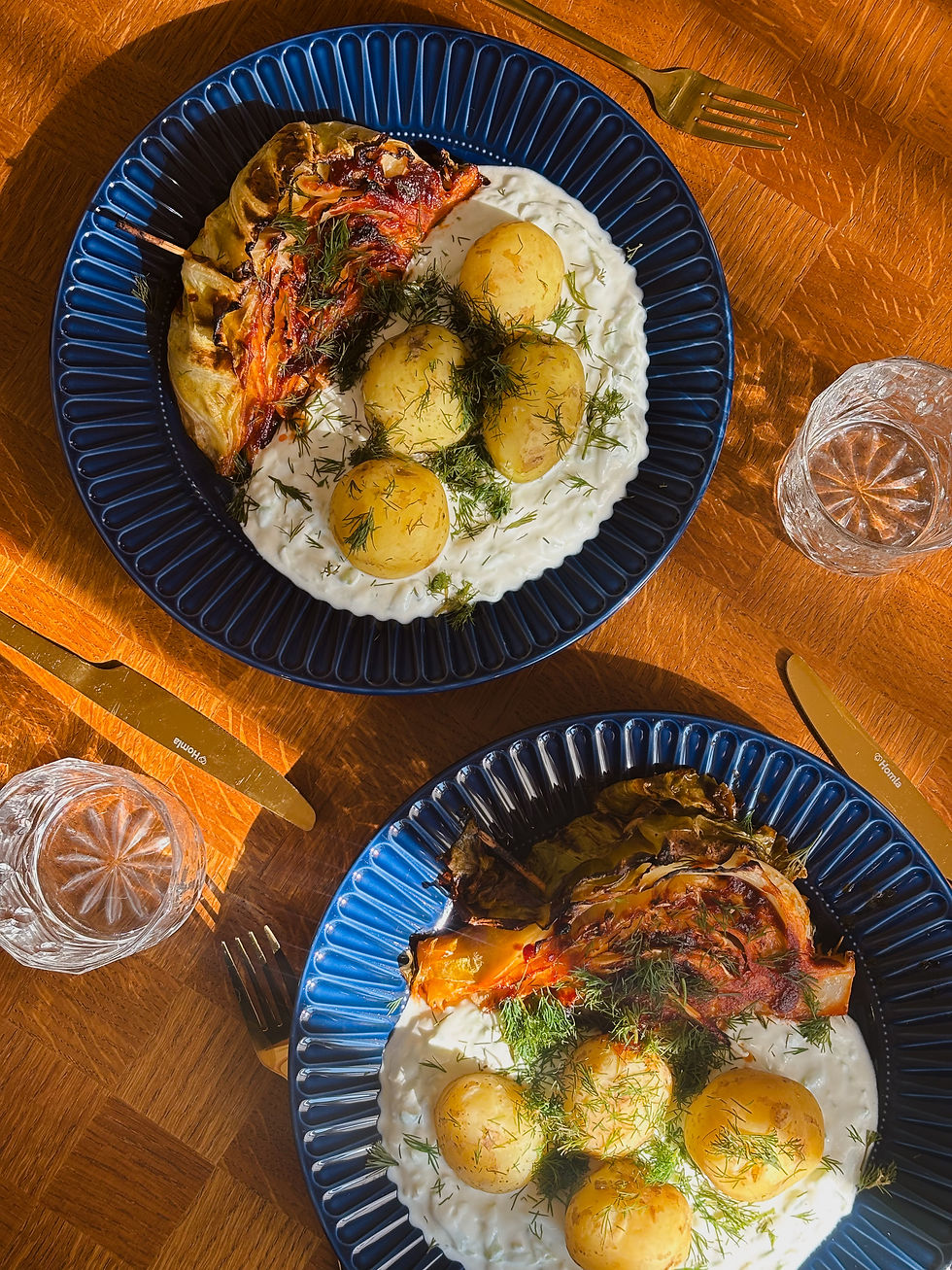 Flatlay wegetariańskiego dania z karmelizowaną kapustą, tzatzikami i młodymi ziemniakami – pomysł na tani i efektowny obiad.