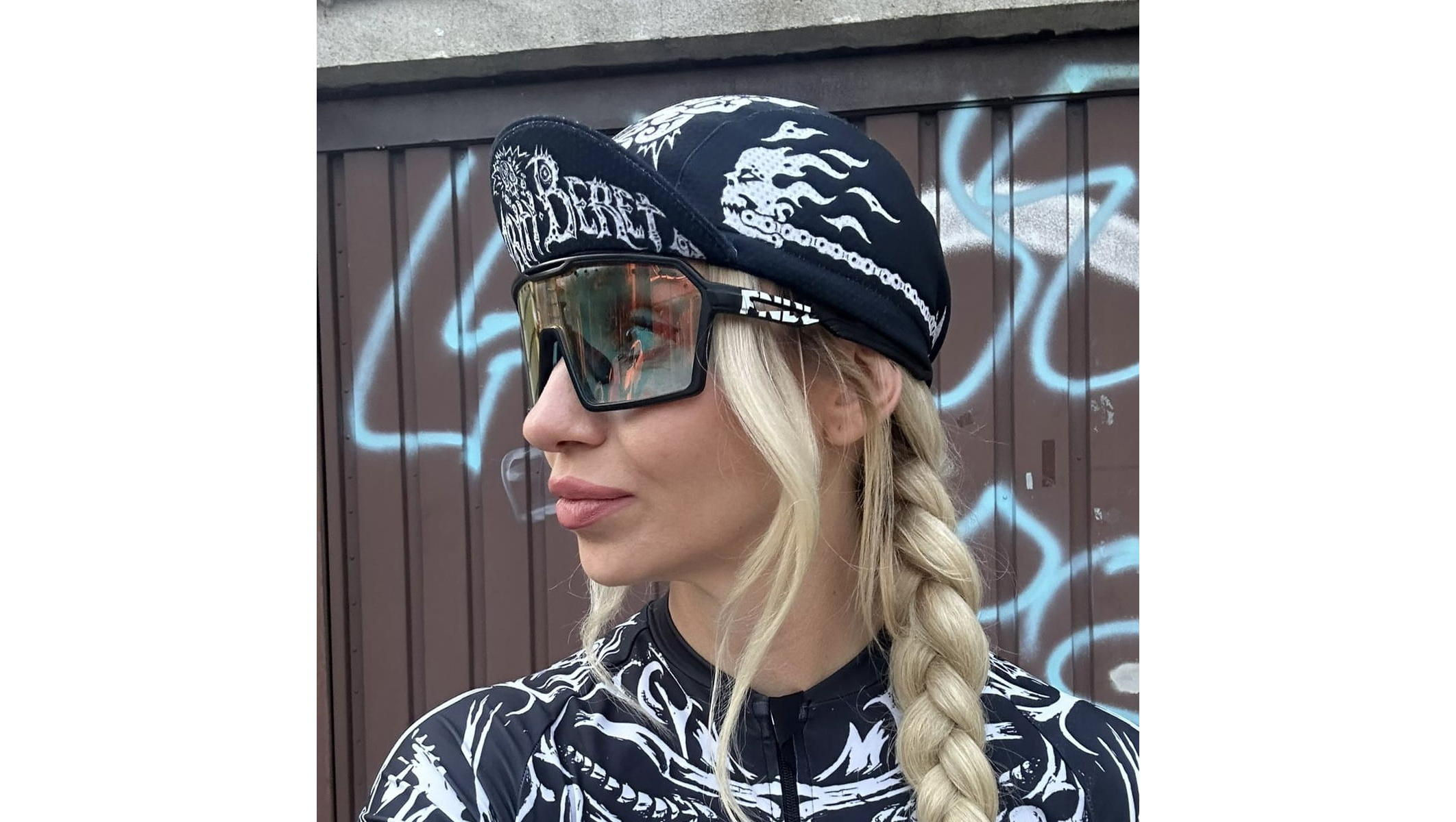 Девушка в велокепке AM Cycling Zryty Beret с белым принтом и надписью на козырьке, вид сбоку