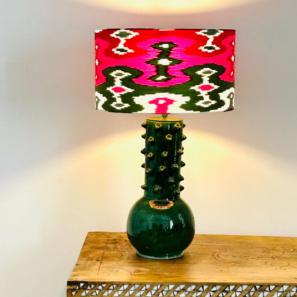 Vue générale de la lampe à poser Gilda Verte allumée, de la marque Empires, avec son abat-jour Samarcande.