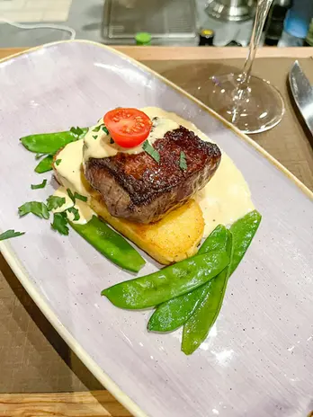Zartes Rinderfilet mit cremiger Sauce, Kartoffeln, Zuckerschoten und Tomate.
