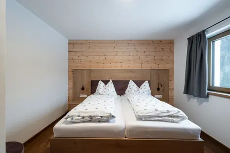 Gemütliches Schlafzimmer mit zwei Betten, Holz-Wand und Fenster. Schlafzimmer Innenraum.