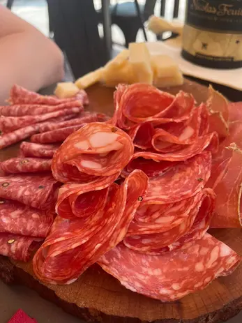 Holzbrett mit reichlich aufgeschnittener Salami, Wurst und Käse