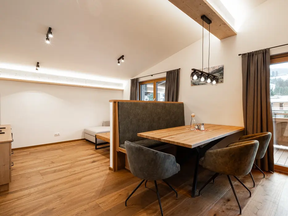 Heller Wohnbereich im Hotelzimmer mit gemütlicher Sitzecke, Sofa und modernem Interieur