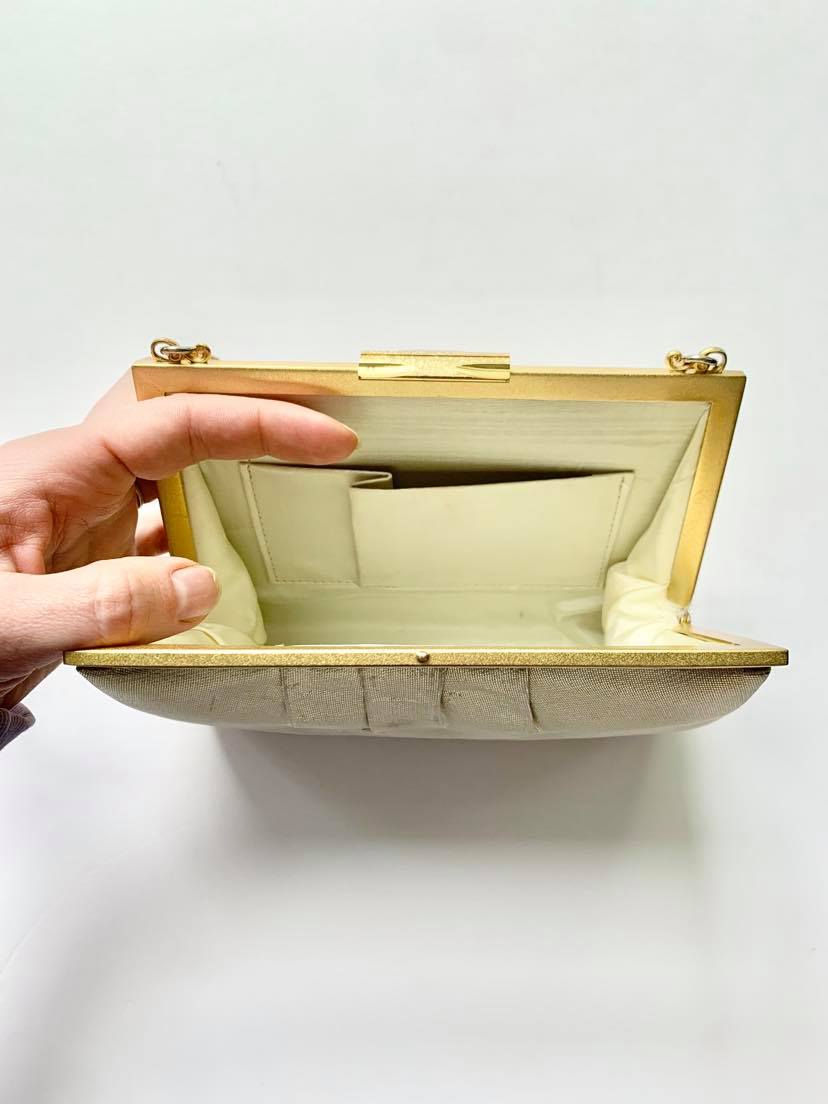 サムネイル： 取手の結びがポイントのゴールドのバッグ