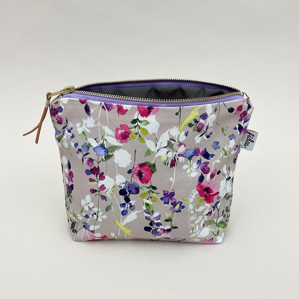 Eine beige MakeUp Tasche mit einem pastelligen Blumendruck und Innenfutter