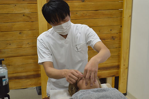美容鍼 施術中の橋岡経男と女性