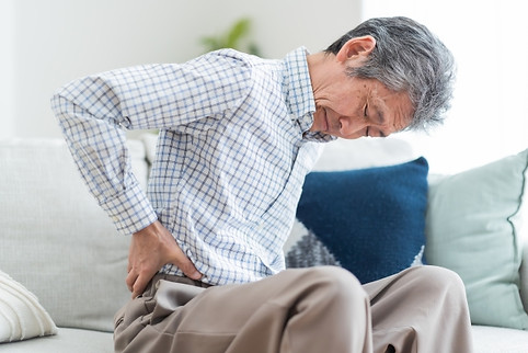 ぎっくり腰で腰をおさえる男性