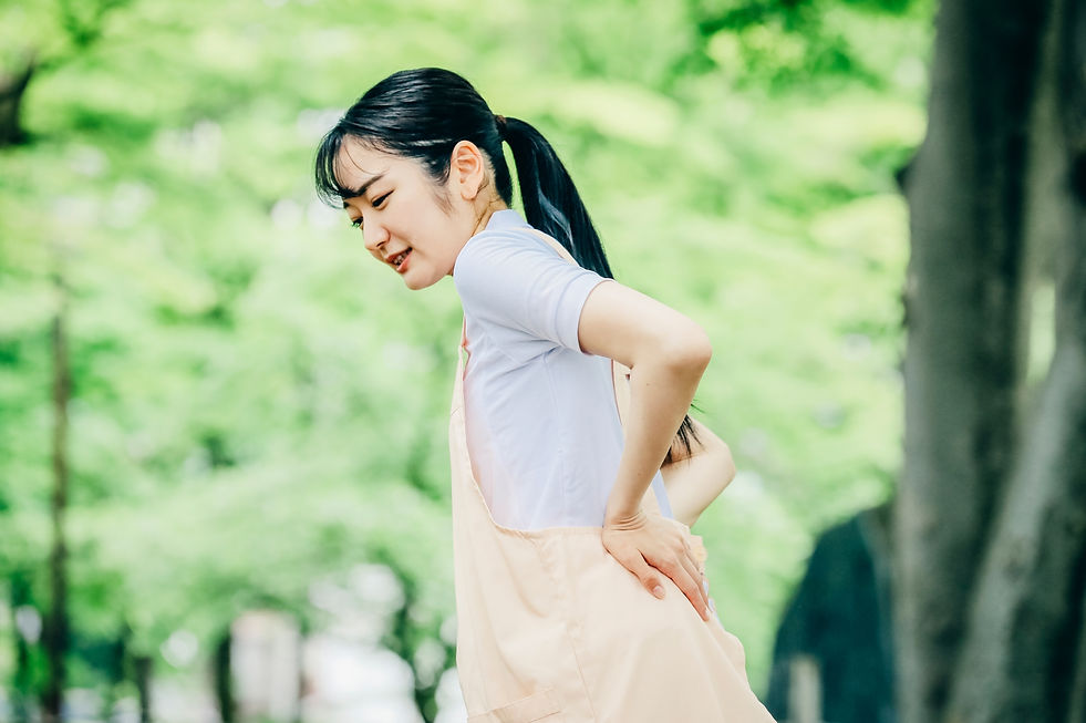 ぎっくり腰で腰をおさえる女性