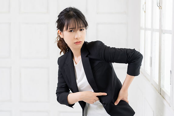 腰に指をさす女性