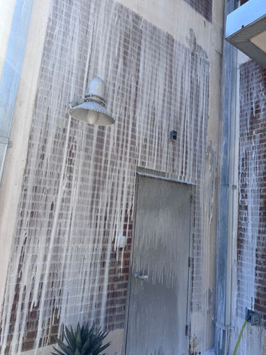 Heavily streaked brick wall and metal door