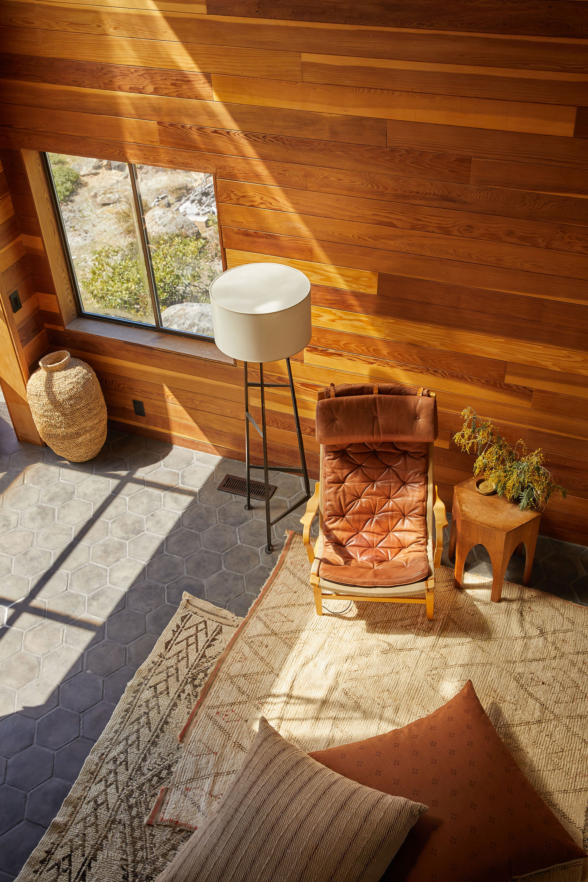 A birdeye view of the living space from the top of the stair. The room have tons of natural light beaming through from the window.