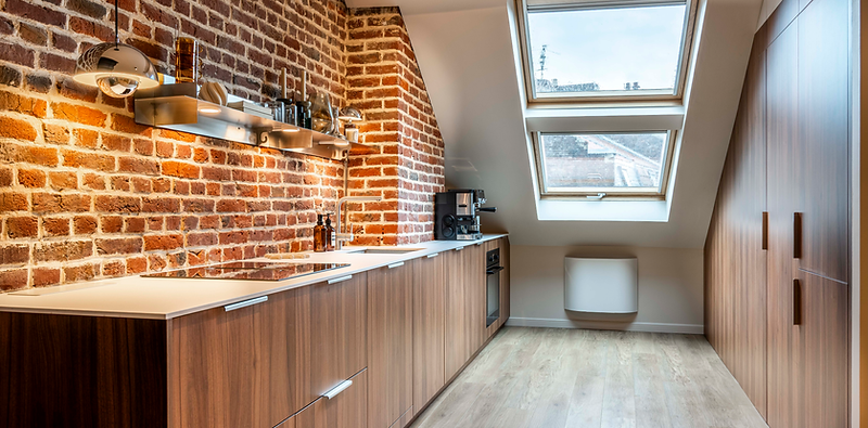 Cuisine sur mesure à Lille centre : façades en décor Noyer, plan de travail en Compact blanc et porte secrète intégrée