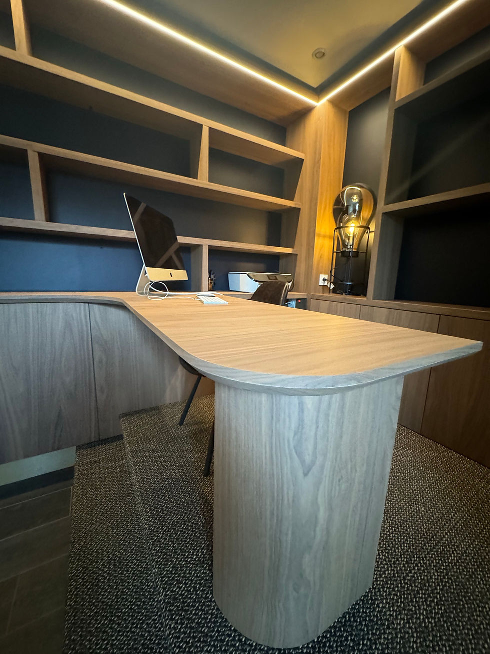 Agencement sur mesure réalisé par MAISONFABRIK pour un particulier à Saint-Omer, composé d’une estrade intégrant un bureau d'angle sur mesure et d’un linéaire de rangements avec bibliothèque rétroéclairée en périphérie. L’ensemble a été conçu en placage noyer véritable Shinnoki, avec sol en sisal gris noir et plinthe en décor effet laiton brossé, pour créer un aménagement à la fois intelligent, chaleureux et haut de gamme.