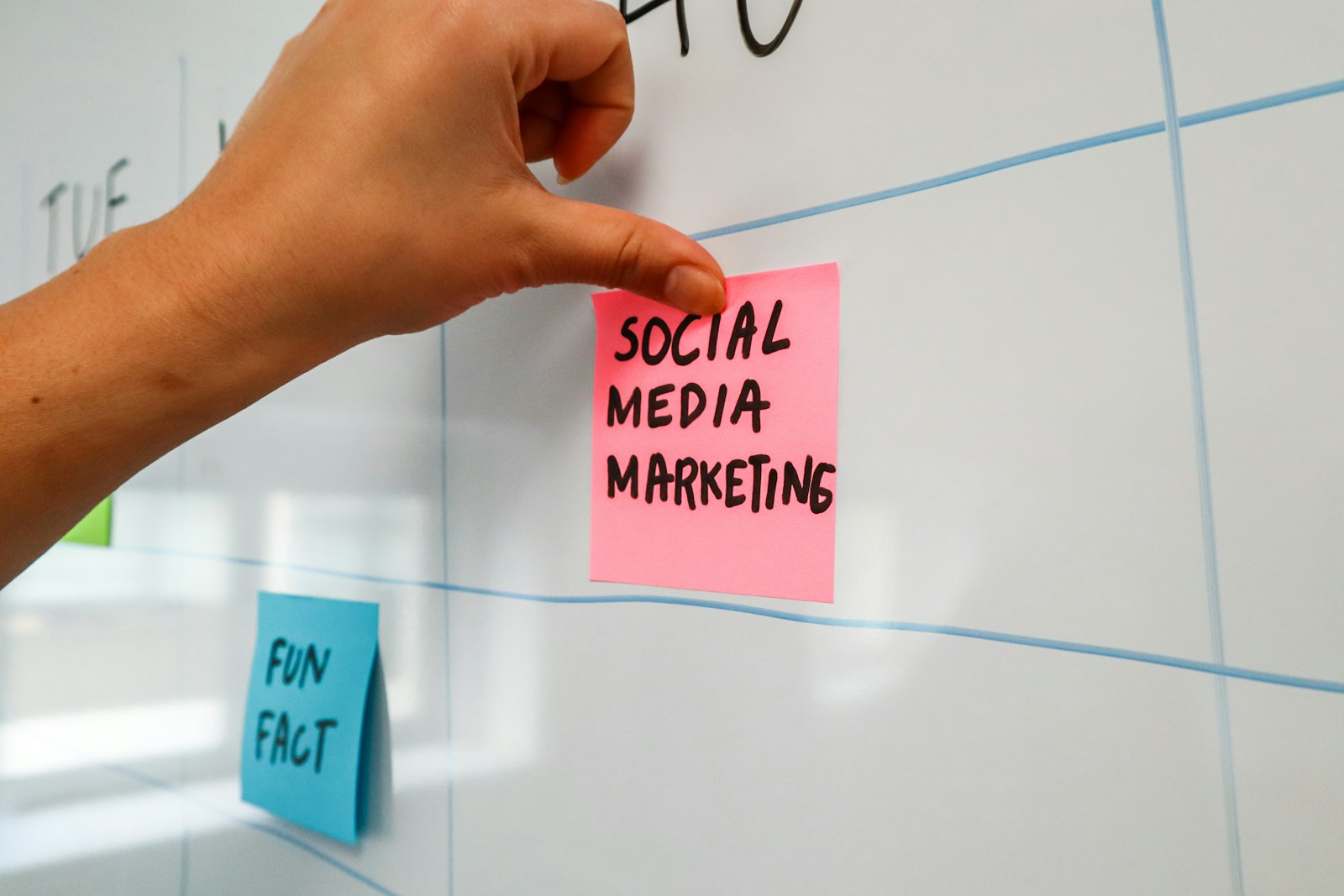 A hand writing on a sticky note during a planning session