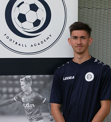 Lead coach Teshone Singh standing next to ELEV8 Football Academy banner located at Bowral Football Club