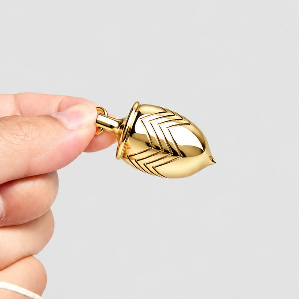 Miniature : Pendule divinatoire en laiton doré tenu entre les doigts, détail des gravures