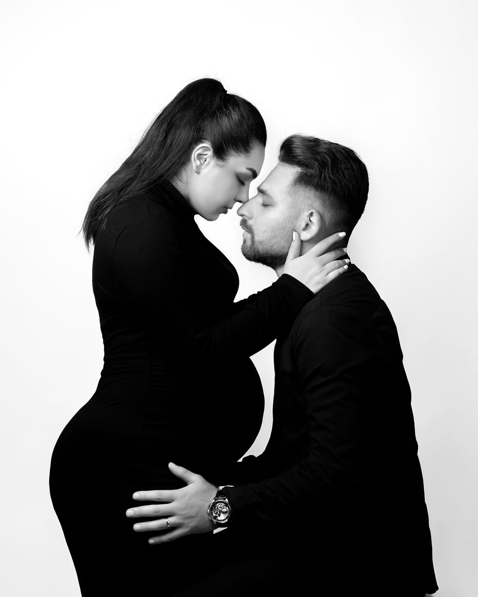 Couple embracing, woman pregnant, black and white photo.