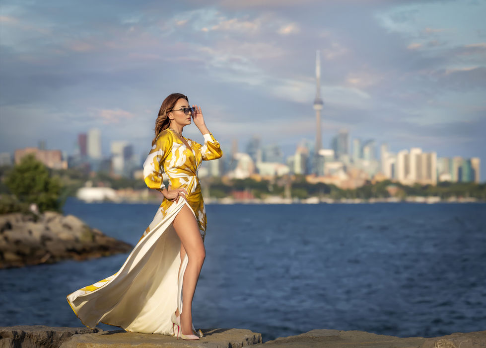 Luxury outdoor photoshoot Toronto by lake with CN Tower skyline and flowing dress