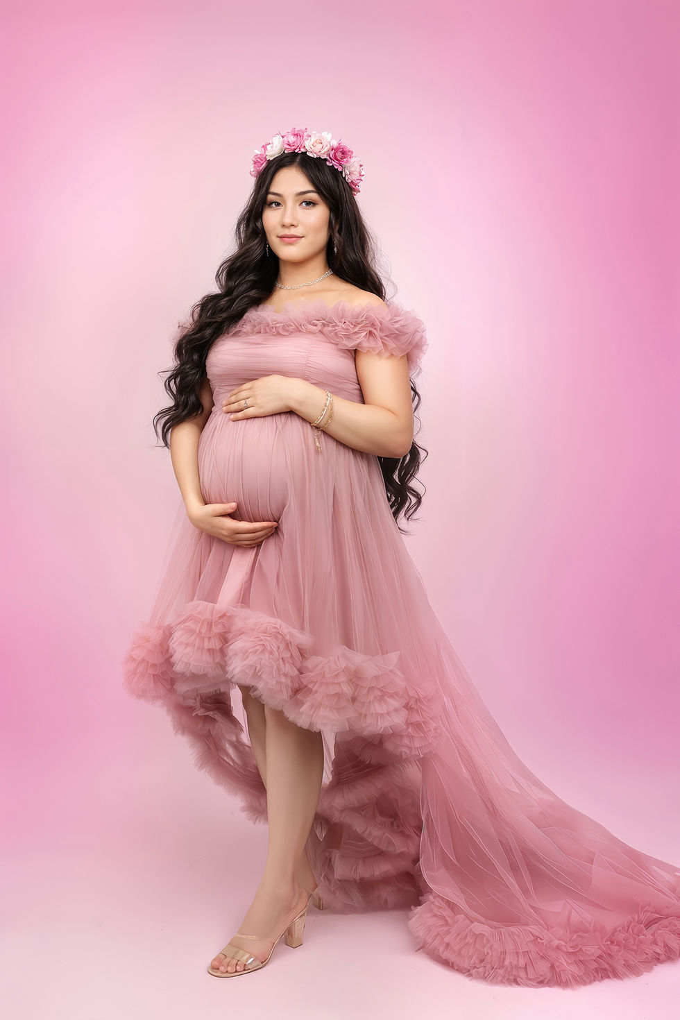 Pregnant woman in pink dress against pink background.