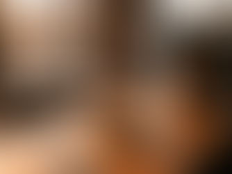 A single donut under a glass dome on an empty coffee shop counter at sunset. AI-generated image.