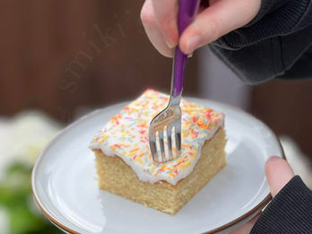 Hands holding a plate with Old School Cake as a fork takes the first bite.