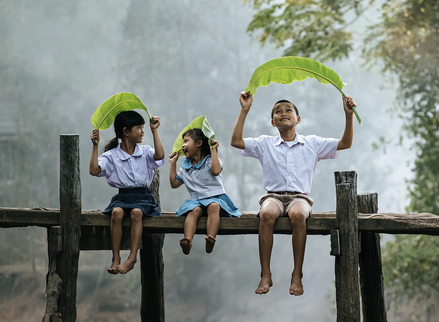 3 enfants vietnamiens jouant sur un pont