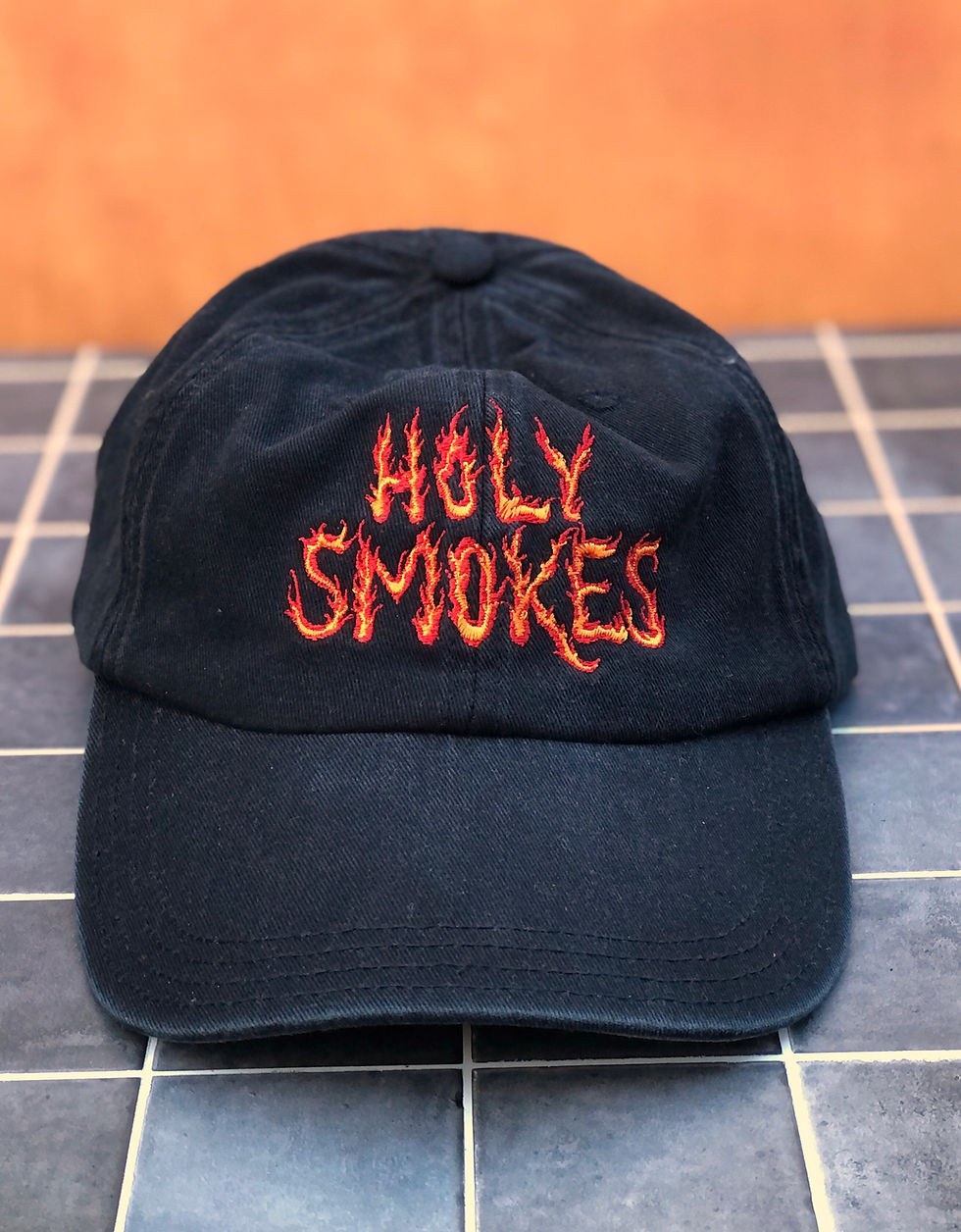 Thumbnail: Black baseball hat embroidered with "Holy Smokes" in orange and red embroidery thread