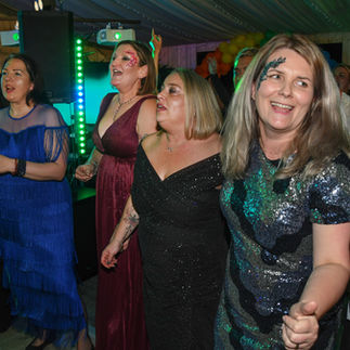 four women standing around smiling and dancing