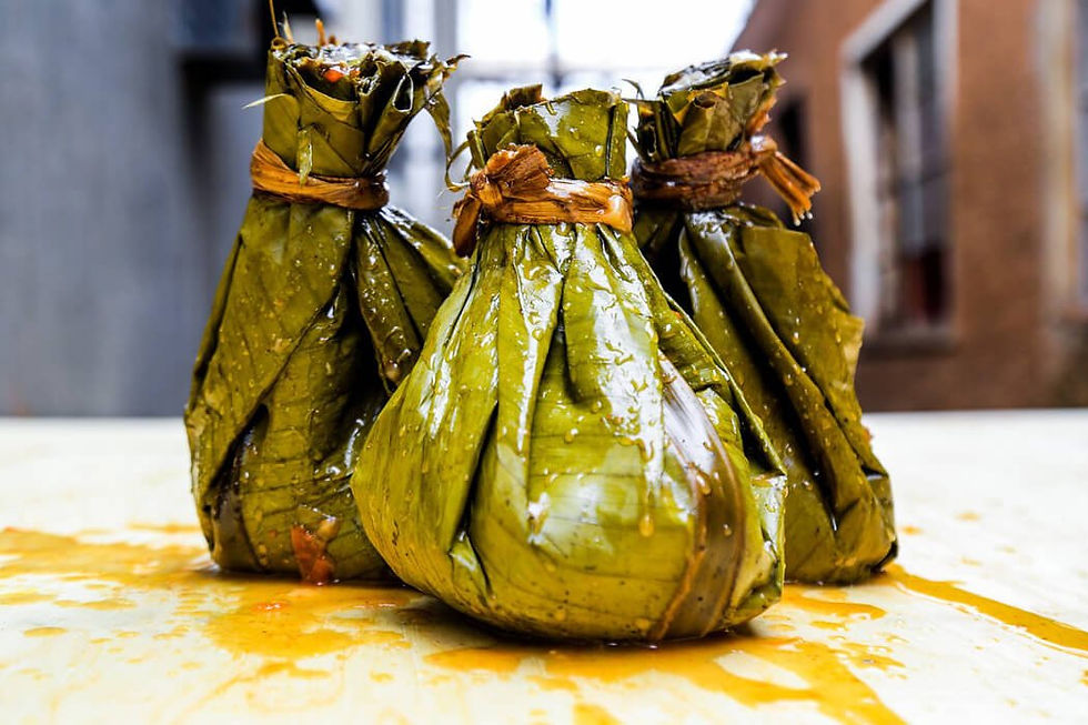 Bundles of the traditional Ugandan dish, Luwombo, wrapped and cooked in aromatic banana leaves.
