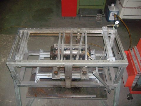 Metal engine block on a testing stand with hoses and a pressure gauge