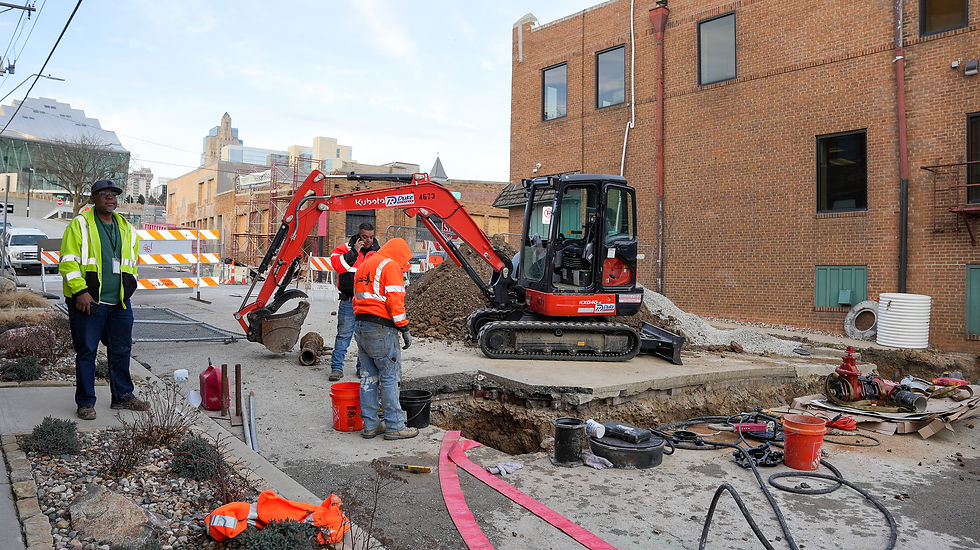 JL Construction workers operating an excavator on Water Main Service project.