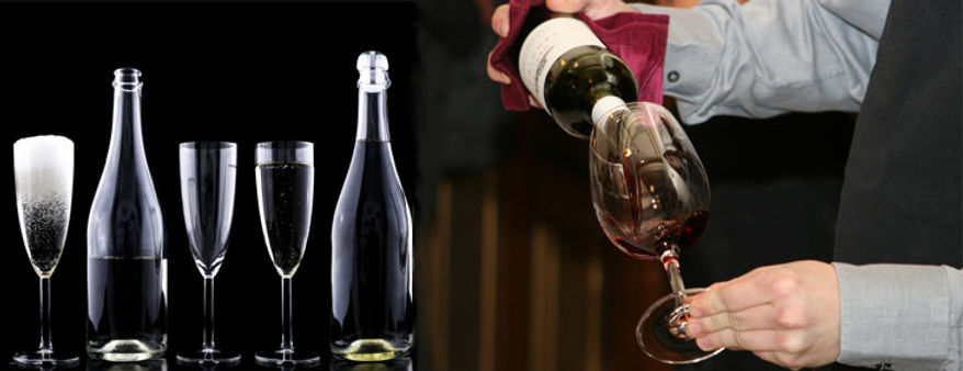 vin rouge versé dans un verre avec bouteilles et verres