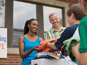 man handing woman some clothing