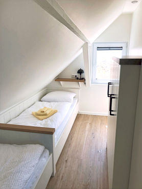 Schlafzimmer mit zwei Einzelbetten und Blick auf den Kniepsand und die Nordsee