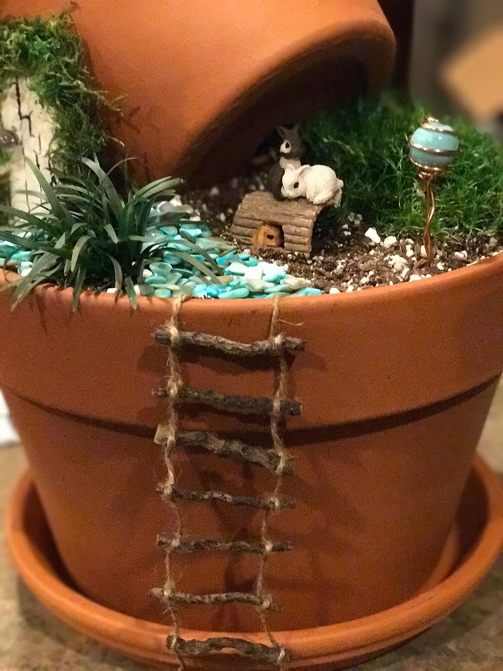 Clay pot fairy garden with ladder, rabbits, gazing ball and door