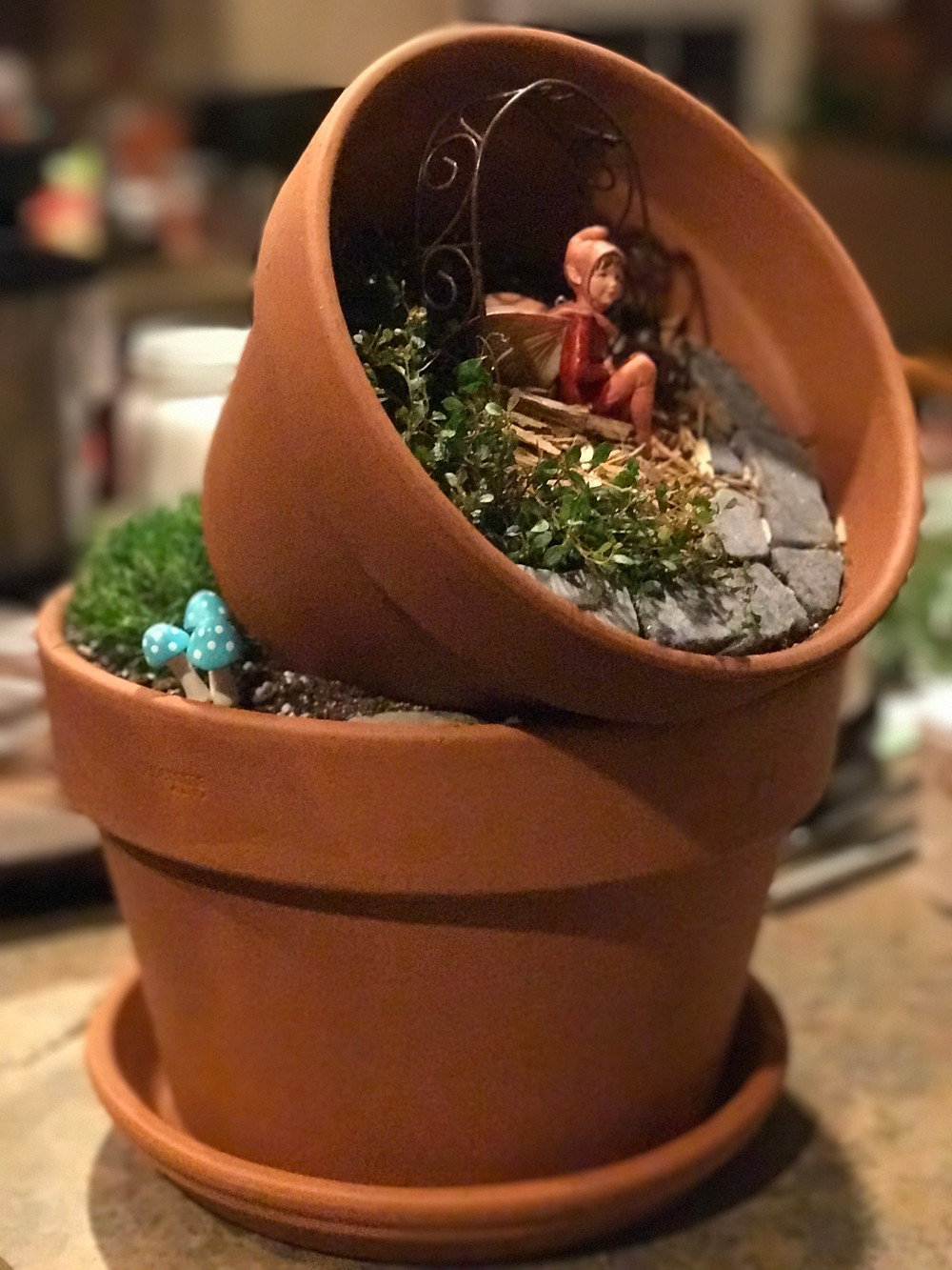 Clay pot fairy garden with fairy, mushrooms and arbor