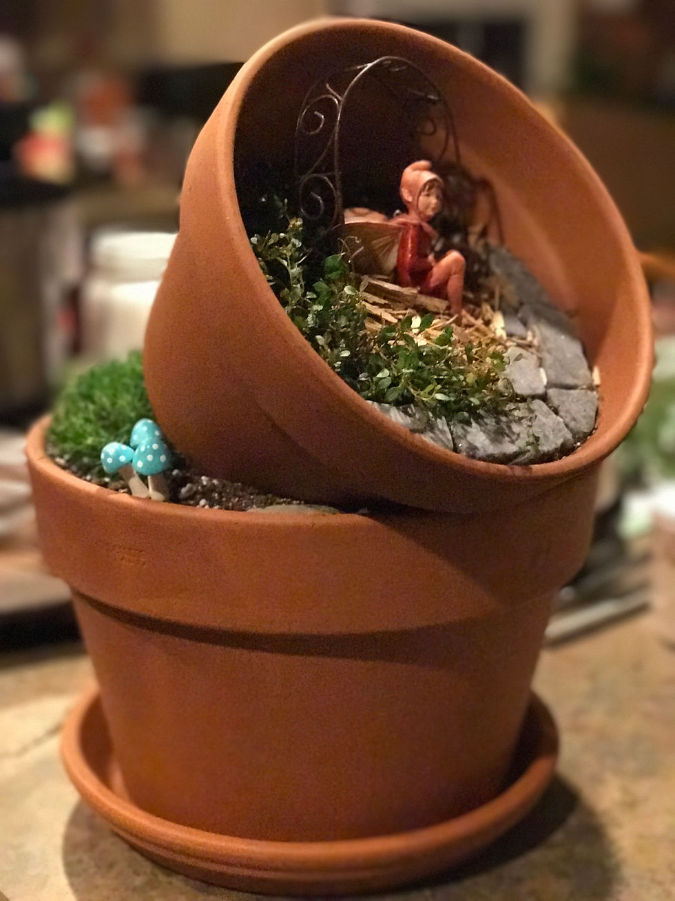 Clay pot fairy garden with fairy, mushrooms and arbor