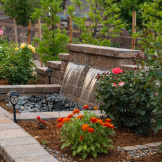 water feature in a landscaped garden with blooming annuals and perennials