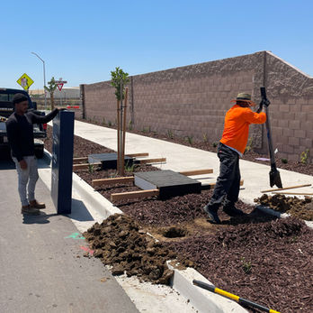 Worker digging whole on sidewalk for new sign