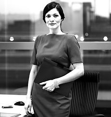 The image showcases a confident businesswoman standing with a laptop in her hand. Her posture exudes authority and influence, making her highly influential among her colleagues. With a poised and professional demeanor, she commands attention and respect. The businesswoman's confident gaze and expression suggest a strong sense of leadership and expertise. Her presence is likely to inspire and motivate her colleagues. The image captures a powerful and influential figure within the business environment, conveying confidence, competence, and the ability to guide and inspire others.