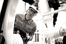 The image portrays a technician diligently working in a workshop. He is focused on analyzing the mechanical part of a machine, demonstrating his commitment to excellence in his work. The technician's body language and posture suggest concentration and expertise as he engages with the machinery. The workshop environment is well-equipped, featuring tools and equipment relevant to his task. The image conveys the technician's dedication, precision, and pursuit of high standards in his mechanical analysis, highlighting his striving for excellence in his craft.