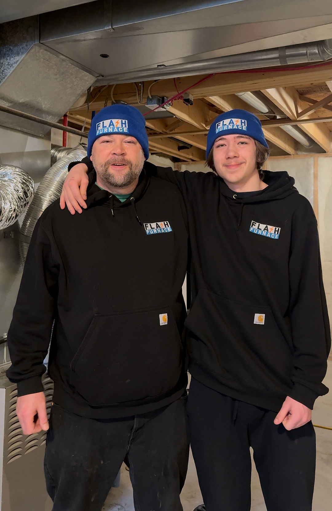 Two Flash Furnace technicians in a Calgary basement