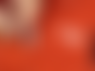 orangey red knit fabric with visible holes. Hands with pins repairing the damage.