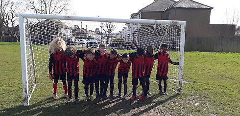 Youth football team lined up on outdoor grass pitch