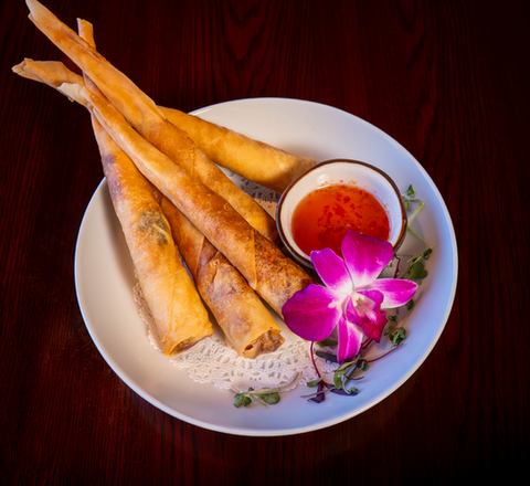 Crispy spring rolls with dipping sauce, flower, and Aiyara Thai Cuisine.